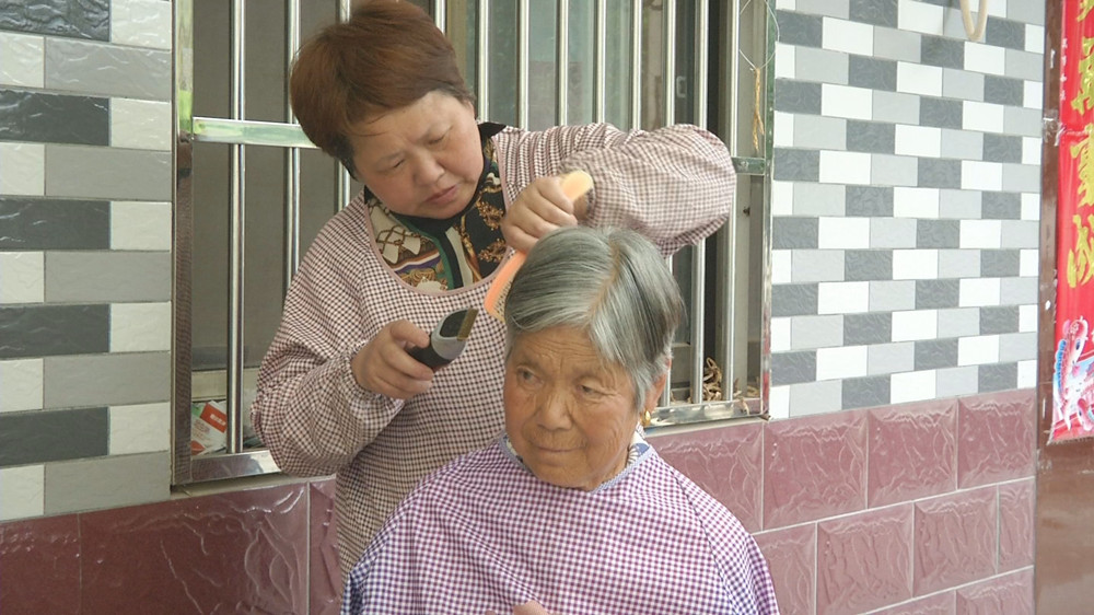 圖為黃志梅為她婆婆理發.jpg