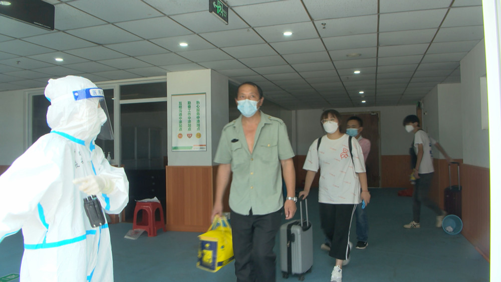 圖為隔離人員在工作人員引導下走出隔離點。.jpg