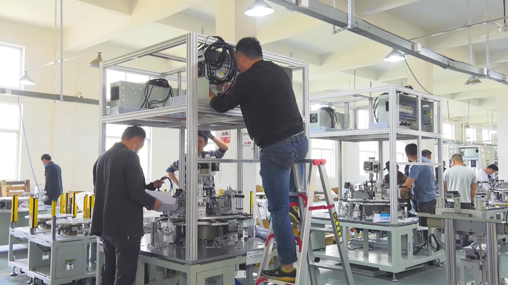 圖為工作人員正在安裝企業自主研發的第三代鋰電池蓋板生產線.jpg