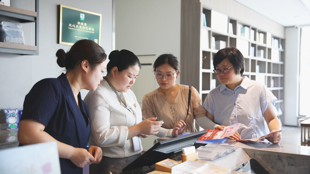圖為龍眠街道盛唐社區工作人員正在某實體店里推廣“三公里”就業圈app.jpg
