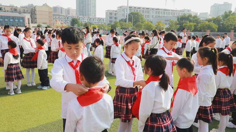 圖為老隊員為新隊員佩戴紅領巾.jpg