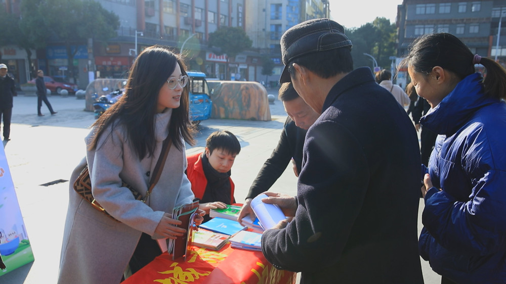 圖為工作人員正在為過往群眾發放宣傳材料，并答疑解惑。.jpg