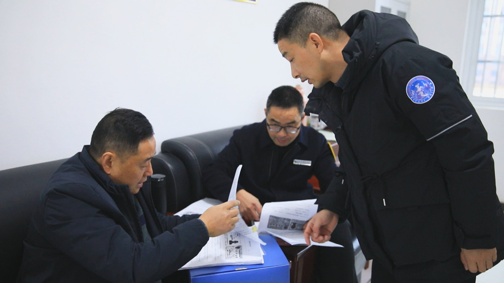 圖為農民工維權工作組正在某項目工地查閱農民工工資發放臺賬.jpg