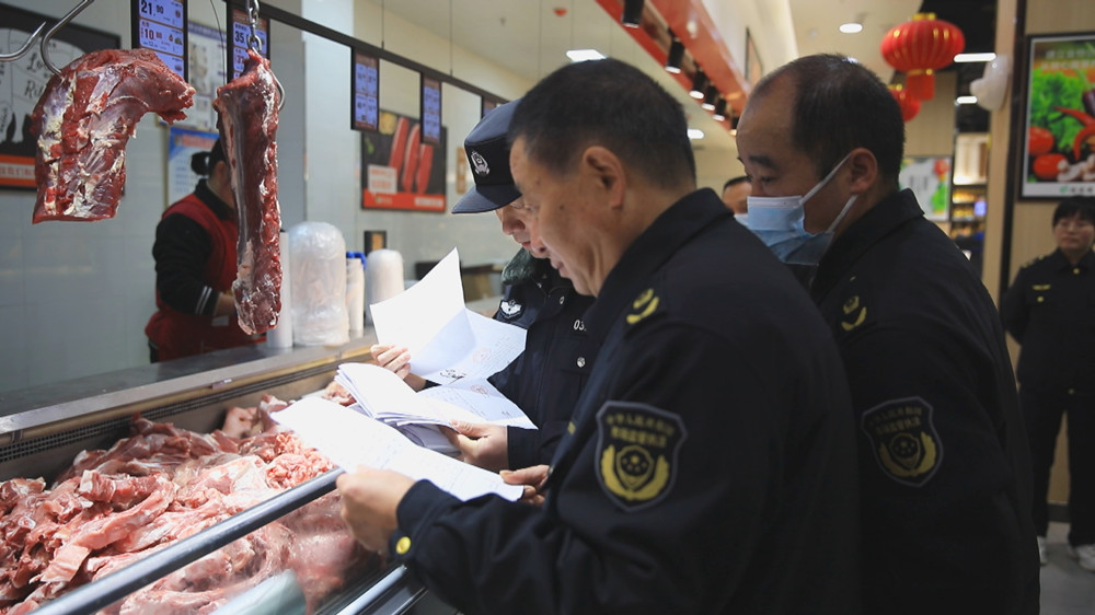 圖為聯合檢查組工作人員正在查驗某商超肉類食品檢驗檢疫合格證等單據.jpg