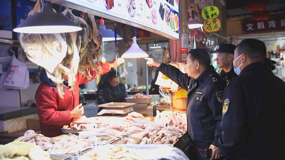 圖為聯合檢查組工作人員正在對某農貿市場內有無使用生鮮燈情況進行檢查.jpg