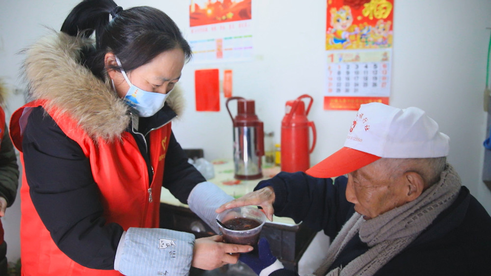 圖為社區志愿者上門送粥給行動不便的居民.jpg