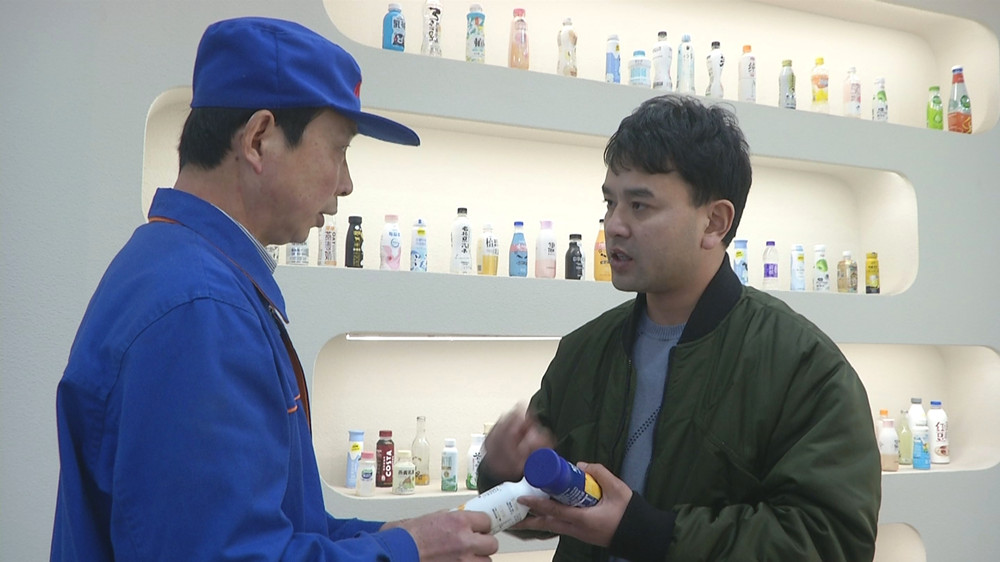 圖為江鵬在產品展示廳了解相關情況.jpg