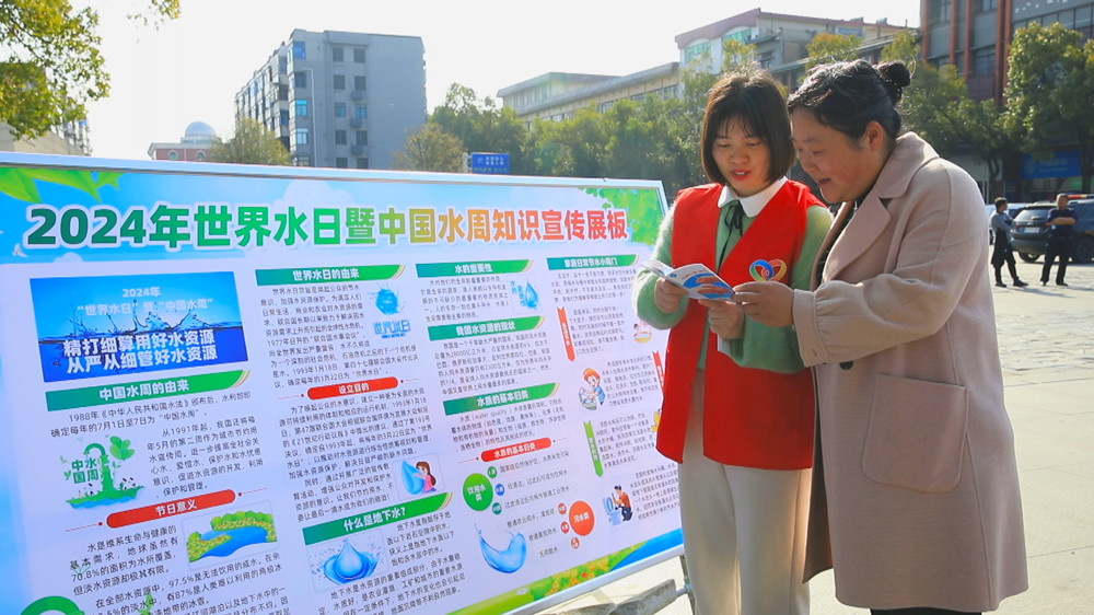 圖為現場工作人員正在給過往市民普及節約用水知識.jpg