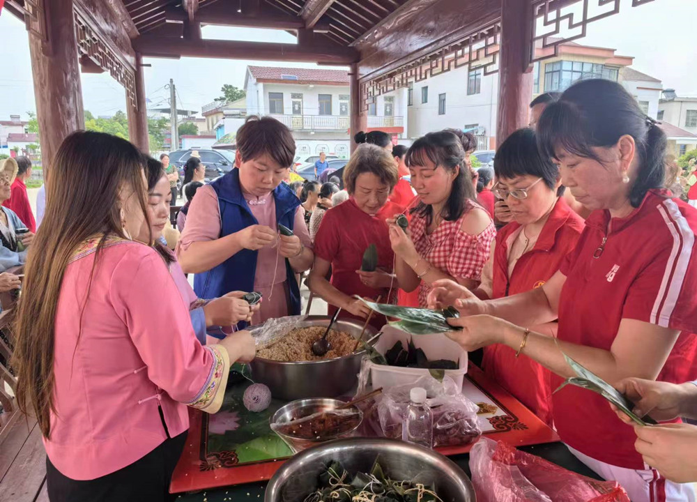 圖為村民和志愿者們共同包粽子。.jpg