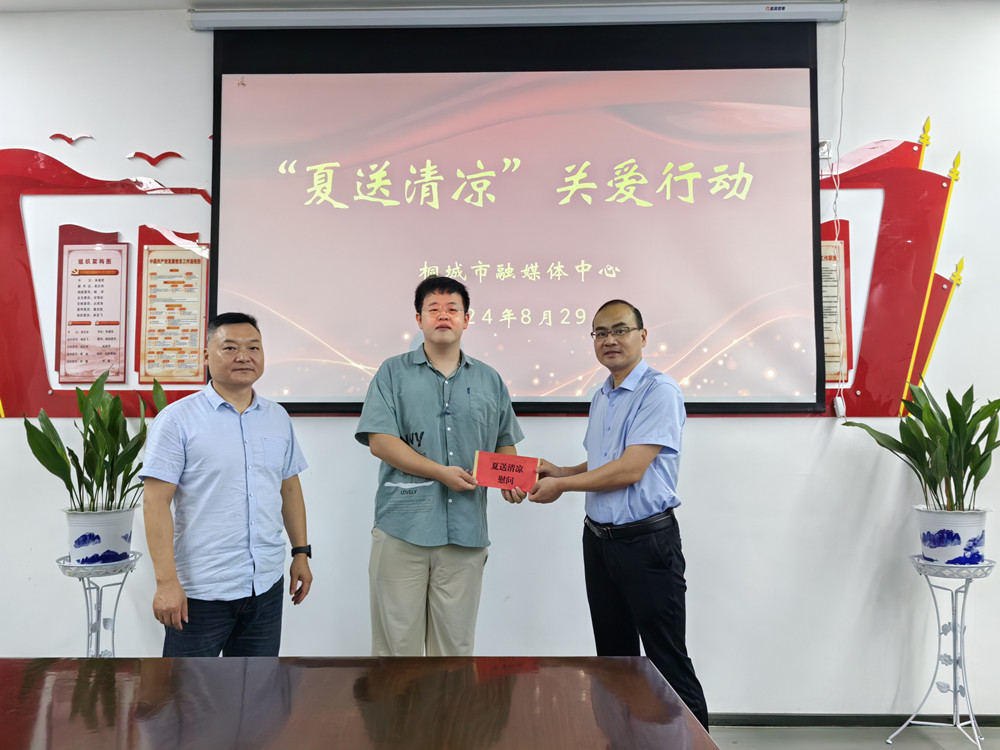 圖為市融媒體中心黨組書記、主任徐基勝和黨組成員、副主任吳文舟為派駐石窯村工作隊隊員李玉衡送上慰問金。.jpg