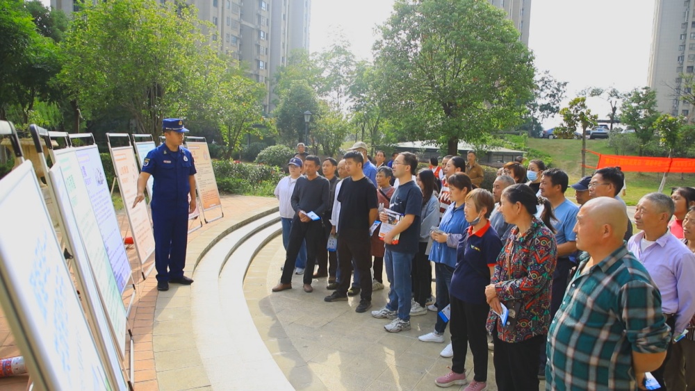 圖為消防員正在結(jié)合展板為小區(qū)居民講解防災(zāi)減災(zāi)自救知識.jpg