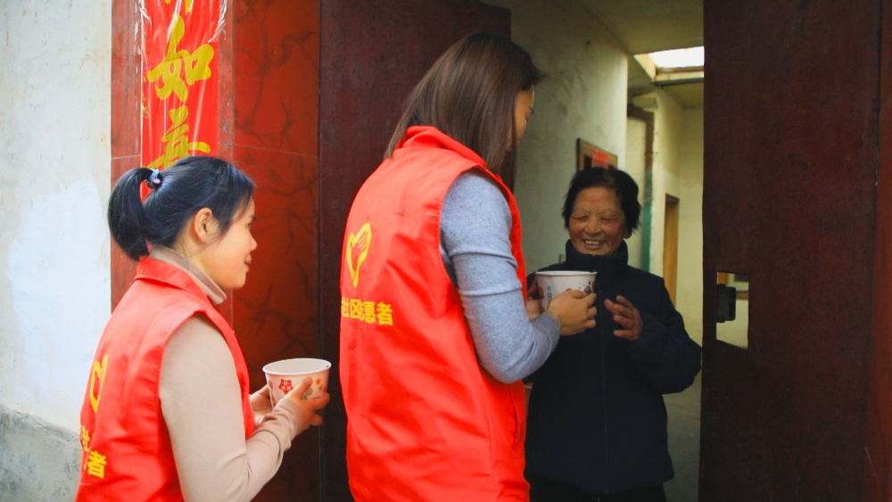 圖為社區志愿者為轄區老人送上臘八粥.jpg
