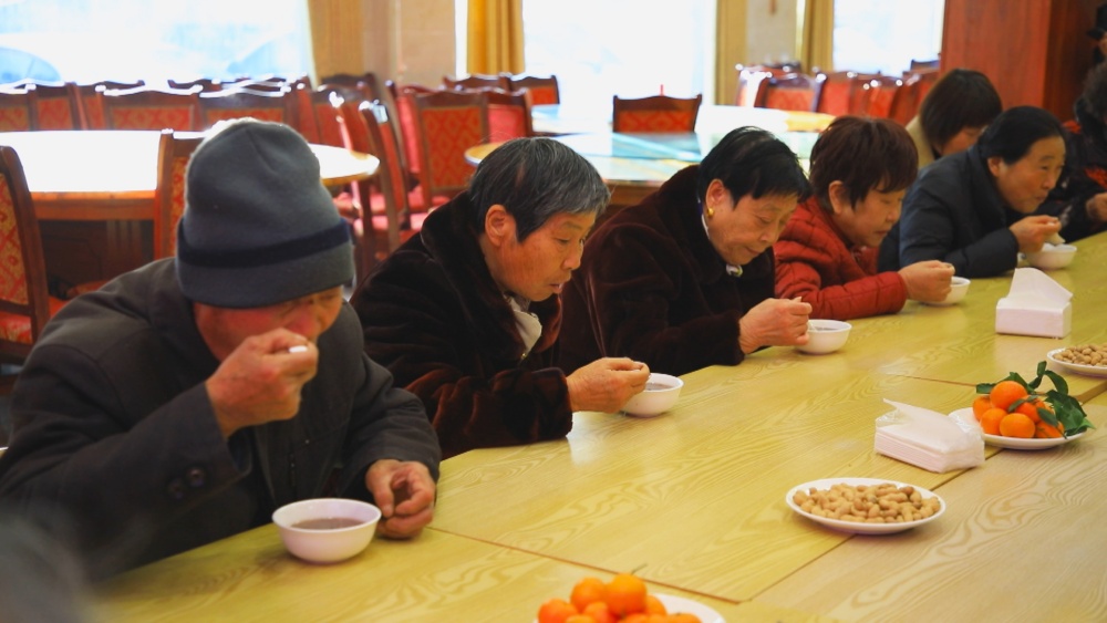 圖為社區居民正在品嘗美味的臘八粥.jpg