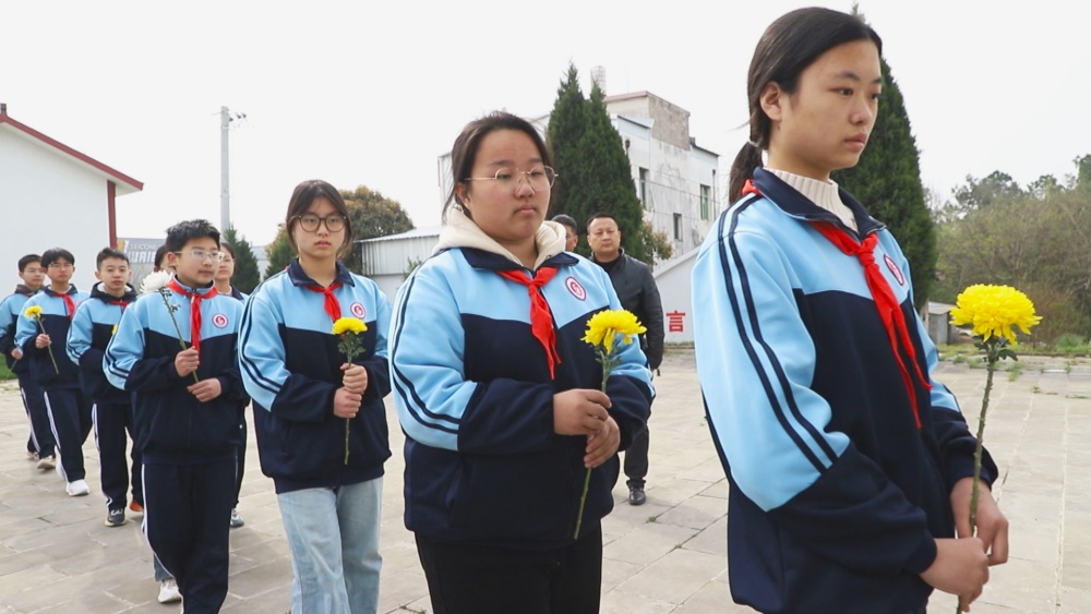 圖為參加活動的學生正在向革命烈士敬獻鮮花.jpg