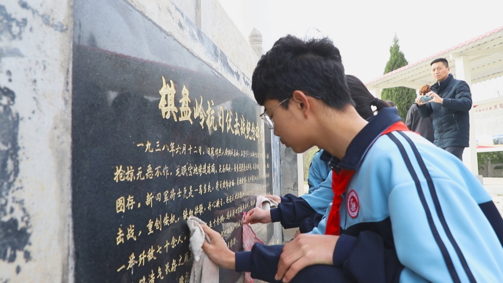 圖為參加活動的學生正在擦拭紀念碑1.jpg