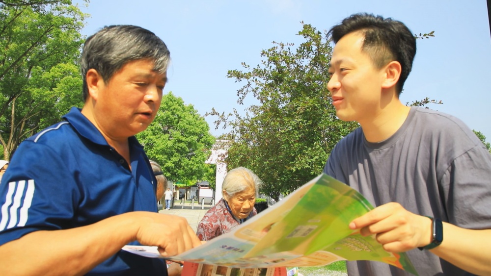 圖為工作人員正在為過(guò)往游客介紹桐城市旅游導(dǎo)覽圖.jpg