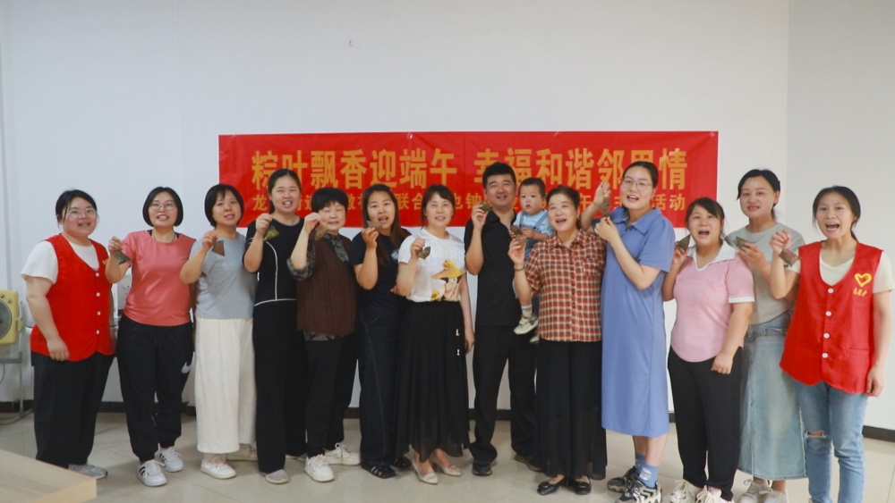 圖為參加活動人員展示自己包的粽子，并祝大家端午安康.jpg