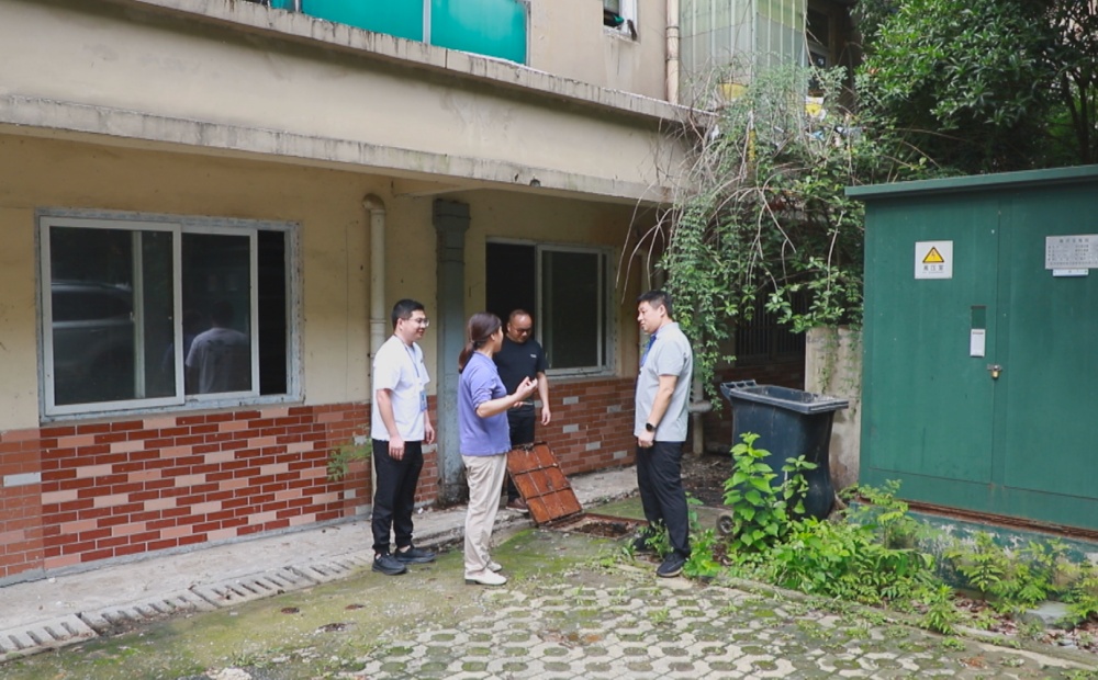 圖為龍騰街道錢莊社區工作人員正在和物業公司及業主共同查看污水管道堵塞情況。.jpg